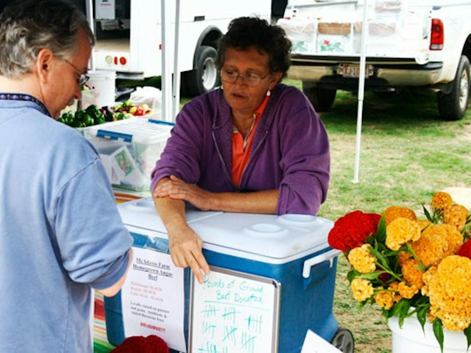 Karen McAdams of McAdams Farm explains how the donation system works at her booth. DTH/Tyler Benton