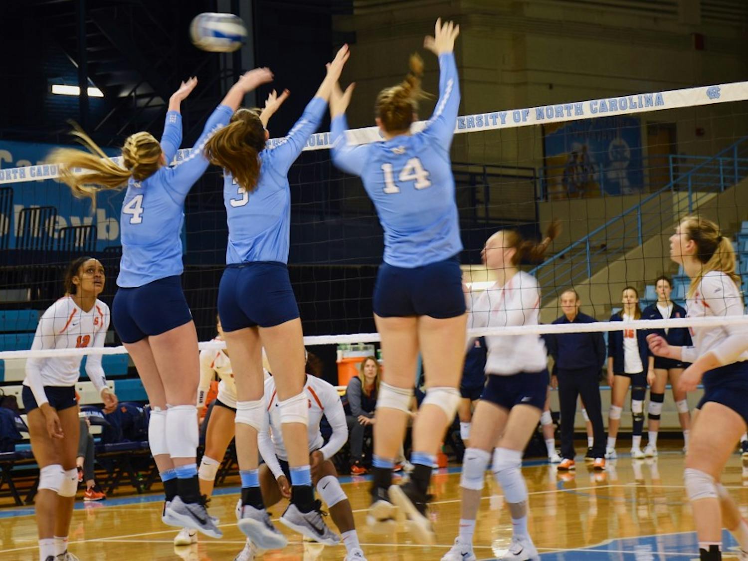 North Carolina hitters Taylor Borup (4), Beth Nordhorn (3) and Madison Laufenberg (14) elevate for a block against Syracuse on Sunday afternoon in Carmichael Arena.