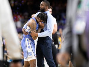 UNC graduate manager Brandon Robinson comforts sophomore guard Caleb Love (2) after a national championship loss to Kansas in New Orleans on Monday, April 4, 2022. UNC lost 72-69.