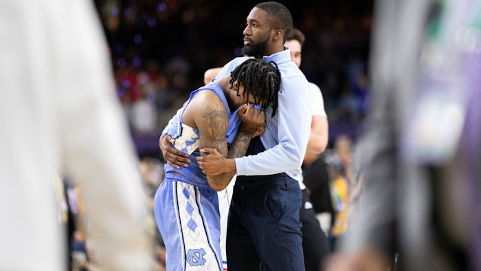 UNC graduate manager Brandon Robinson comforts sophomore guard Caleb Love (2) after a national championship loss to Kansas in New Orleans on Monday, April 4, 2022. UNC lost  72-69.