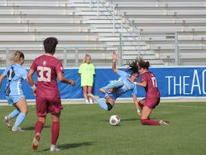 Alex Kimball (47), a redshirt senior midfielder for the Tar Heels' women's soccer team, takes a hard tackle from a defender during the 2018 ACC Championship game against Florida State on Sunday, Nov. 4.