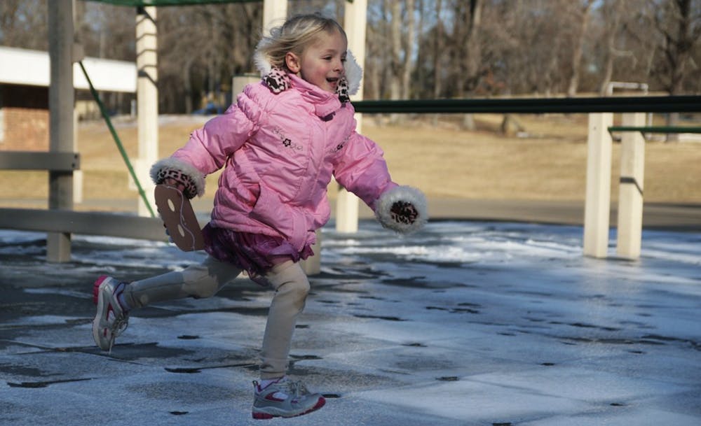 Kendra Kulberg runs across the ice in front of the monkey bars, which the children are not allowed to use. Last week ice severely limited the area children could play in during recess.