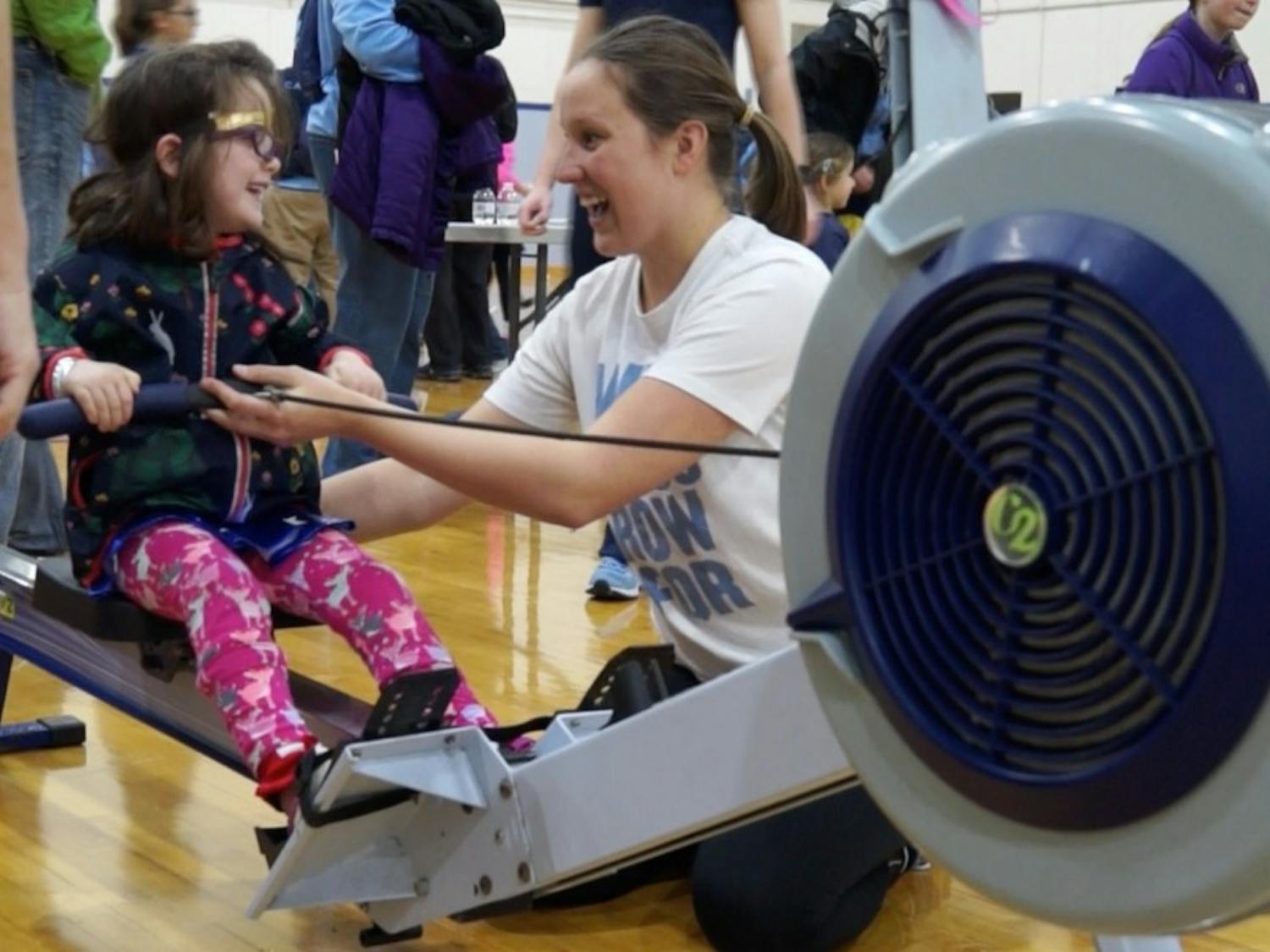 Caroline Young, who is on UNC's women's rowing team, teaches a young girl how to row during National Girls and Women in Sports Day hosted at UNC.