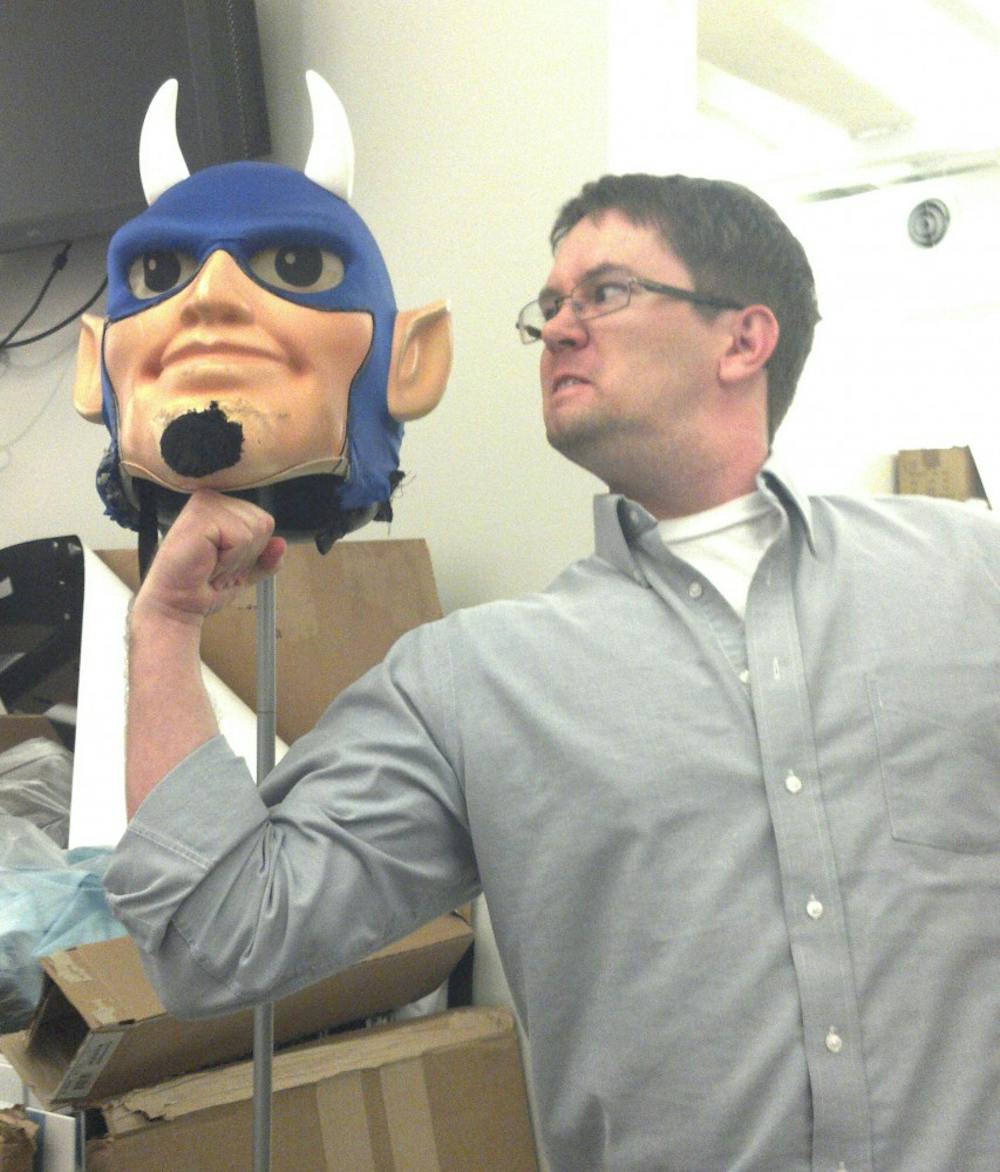 	Kyle McKay, a marketing manager at Student Stores, poses with the head of the Duke Blue Devil mascot costume.