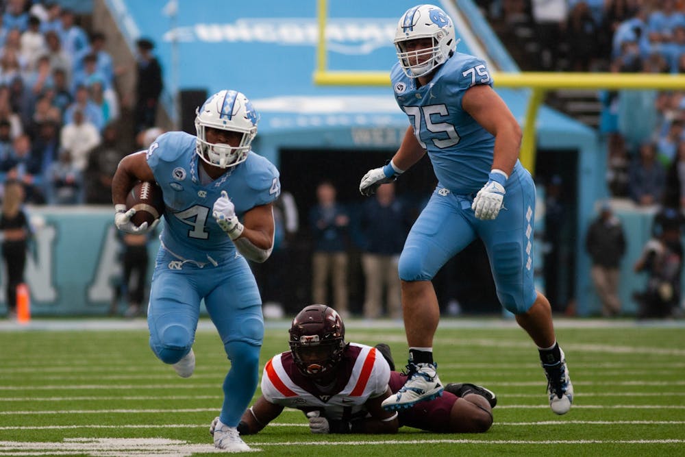 UNC sophomore running back Caleb Hood (4) runs past a tackle during a home football game at Kenan Stadium against Virginia Tech on Saturday, Oct. 1, 2022. UNC won 41-10.