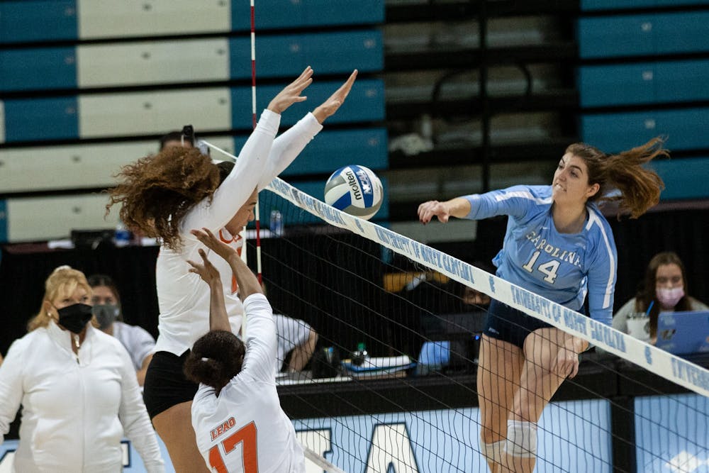 Sophomore outside hitter Kaya Merkler (14) attempts a spike in the senior day match against the University of Miami on Sunday, Nov. 21, 2021. The Tar Heels fell to the Hurricanes in a five-set match.