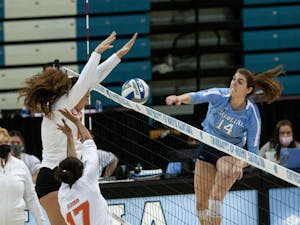 Sophomore outside hitter Kaya Merkler (14) attempts a spike in the senior day match against the University of Miami on Sunday, Nov. 21, 2021. The Tar Heels fell to the Hurricanes in a five-set match.