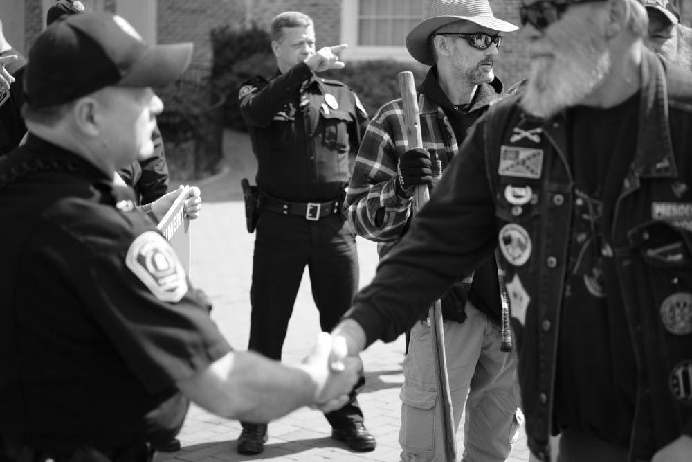 <p>A pro-Confederate protester shakes hands with UNC Police officer Timothy Tickle after Tickle explained to protesters the boundaries of UNC's campus on March, 16, 2019.The pro-Confederate group then left campus. Photo courtesy of Daniel Hosterman.</p>