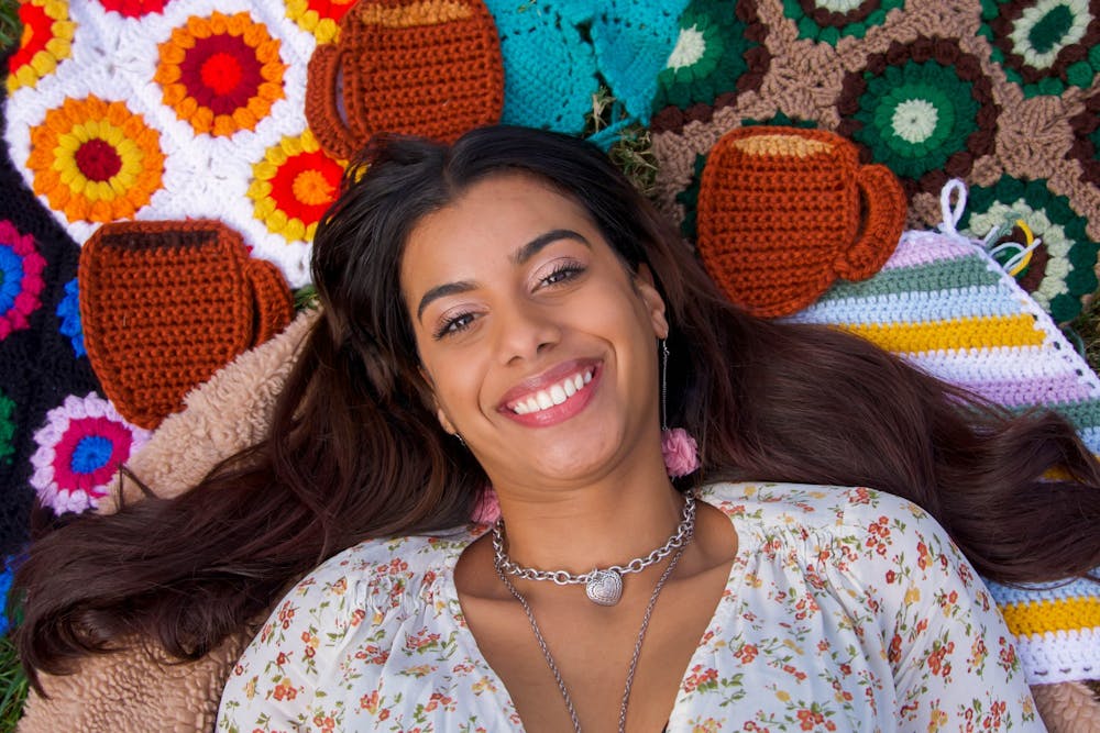 Tiffany Melenzio, founder and owner of Cup of T, poses for a portrait with their signature handmade items. Products range from tote bags to crocheted tops. "Now, that's my cup of t," smiled Melenzio.