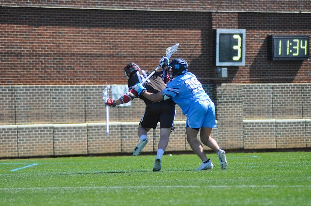 UNC sophomore Cooper Frankenheimer (19) defends his man during the men's lacrosse game against Brown at Dorrance Field on Saturday, March 11, 2023. UNC won 19-6.
