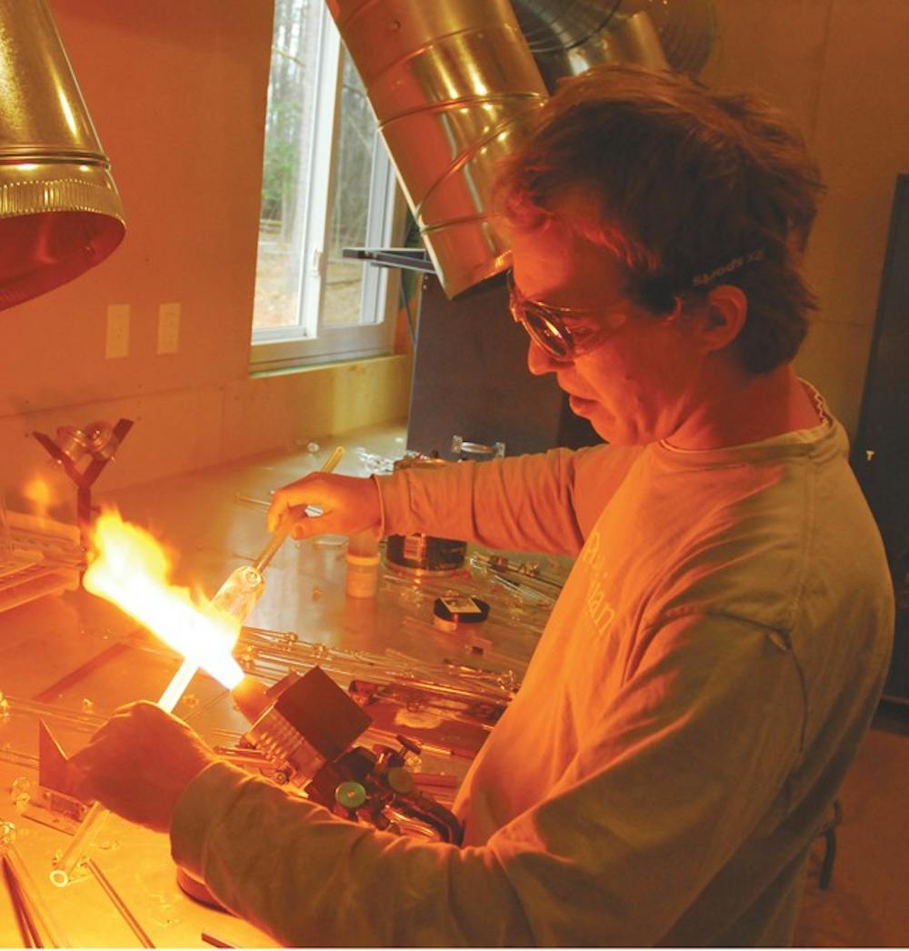 Jonathan Davis uses a torch to shape a glass piece. DTH/ /Lauren Vied