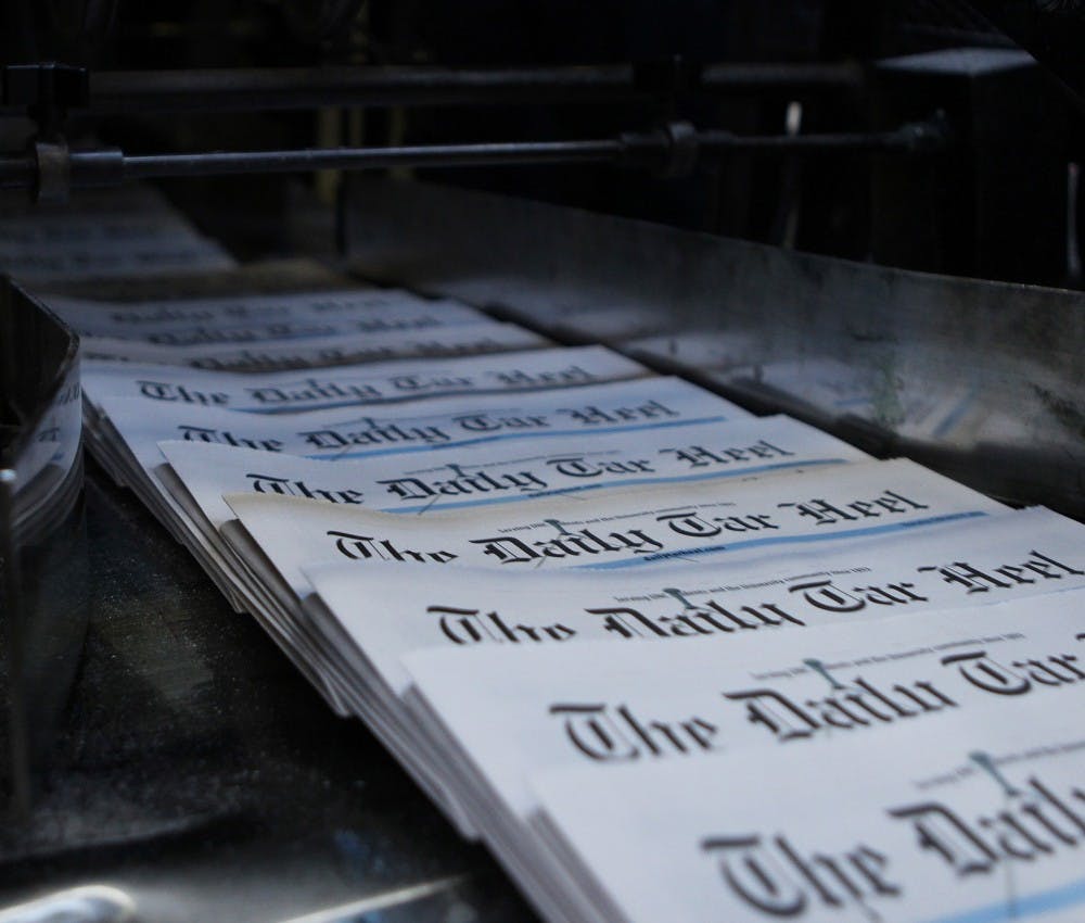 <p>Newspapers come off the press to be bundled for delivery.&nbsp;</p>