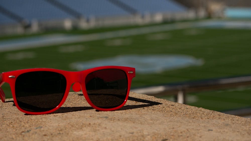 <p>DTH Photo Illustration. A pair of red plastic sunglasses rest next to a stairwell at Kenan Stadium at the University of North Carolina at Chapel Hill on Thursday, April 13, 2023.</p>