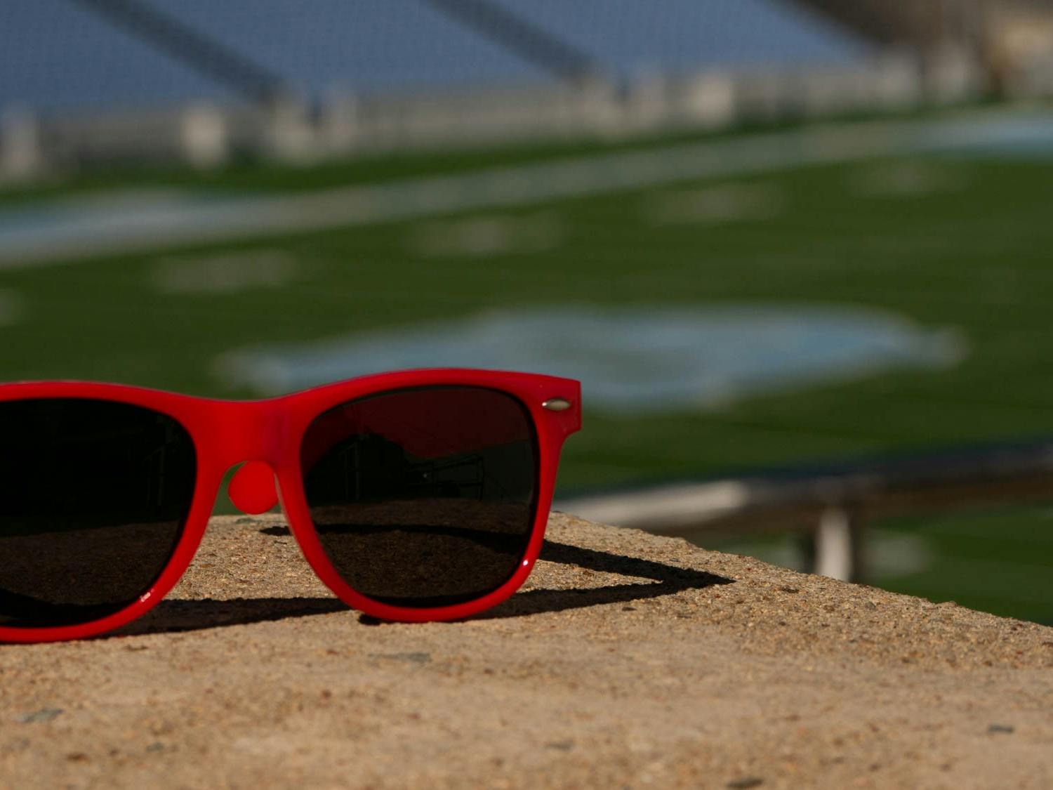 DTH Photo Illustration. A pair of red plastic sunglasses rest next to a stairwell at Kenan Stadium at the University of North Carolina at Chapel Hill on Thursday, April 13, 2023.
