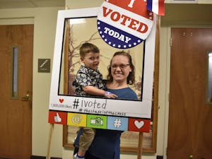 Melanie Unwin and her son take a picture together after she cast her vote at the Chapel of the Cross church at 304 E. Franklin St. on Oct. 23, 2018 helping voters register. The Chapel of the Cross severs as an early voter location close to the University of North Carolina at Chapel Hill's campus. 