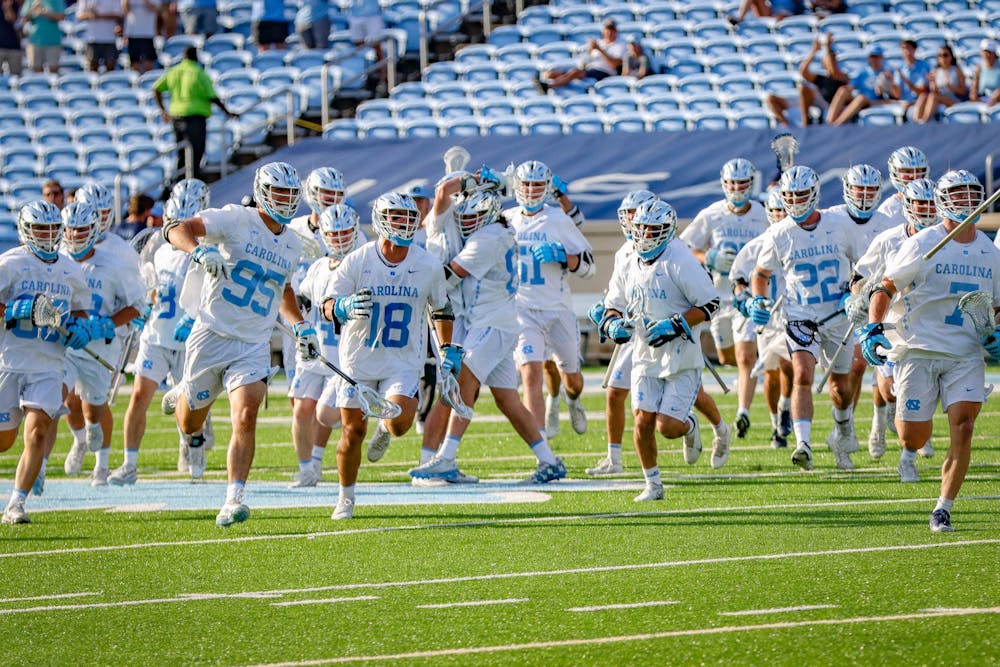 The UNC men's lacrosse team storms the field after the Tar Heels' 15-12 victory against Duke on Sunday, May 2. With the victory, UNC and Duke share the 2021 ACC regular season title.