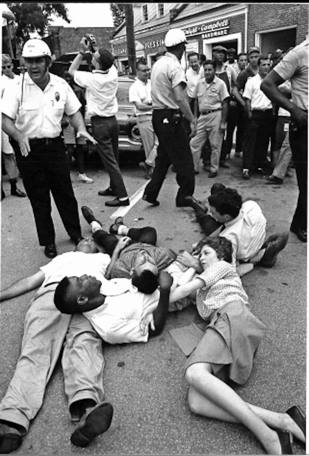 <p>Photo courtesy of Chapel Hill Public Library, from their book "Courage in the Moment. The Civil Rights Struggle 1961-1964" photographed by Jim Wallace. Protestors had to agree to practice nonviolent resistance by neither assisting or resisting arrest, here the demonstrators are lying on Franklin Street, according to the book.&nbsp;</p>