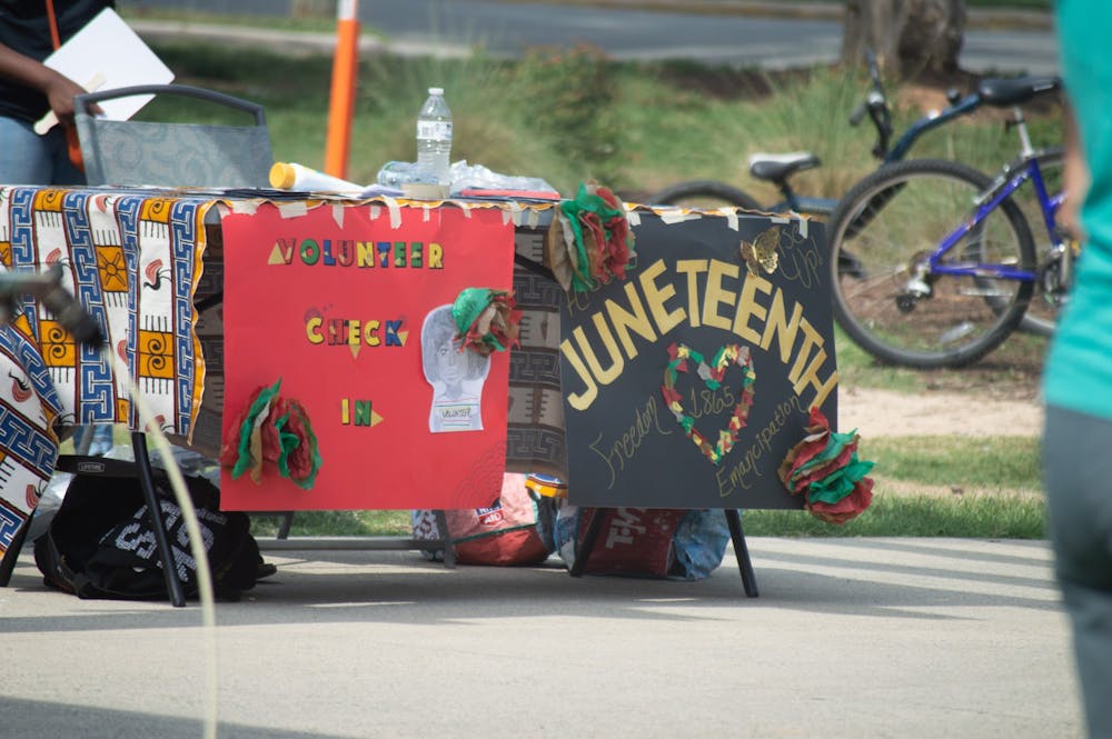 <p>The volunteer booth for the 2021 NAACP Youth Council Juneteenth Celebration is decorated in colorful Juneteenth signs.</p>