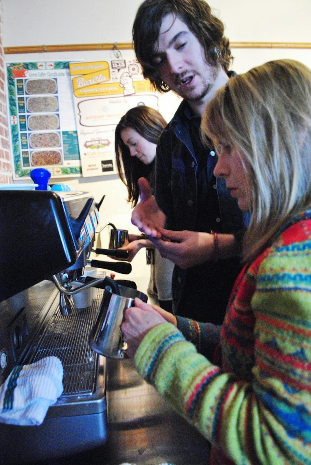 	Open Eye barista, Miles Murray, teaches Candy Cooper how to steam milk and make latte designs on Saturday morning.