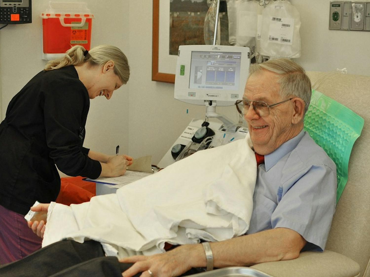 Al Whitney, 77, jokes with phlebotomist Stephanie Anthony as he donates his 750th unit of platelets at the Blood Donation Center at UNC Hospitals on Tuesday morning. Whitney has donated platelets in all 50 states and three countries.