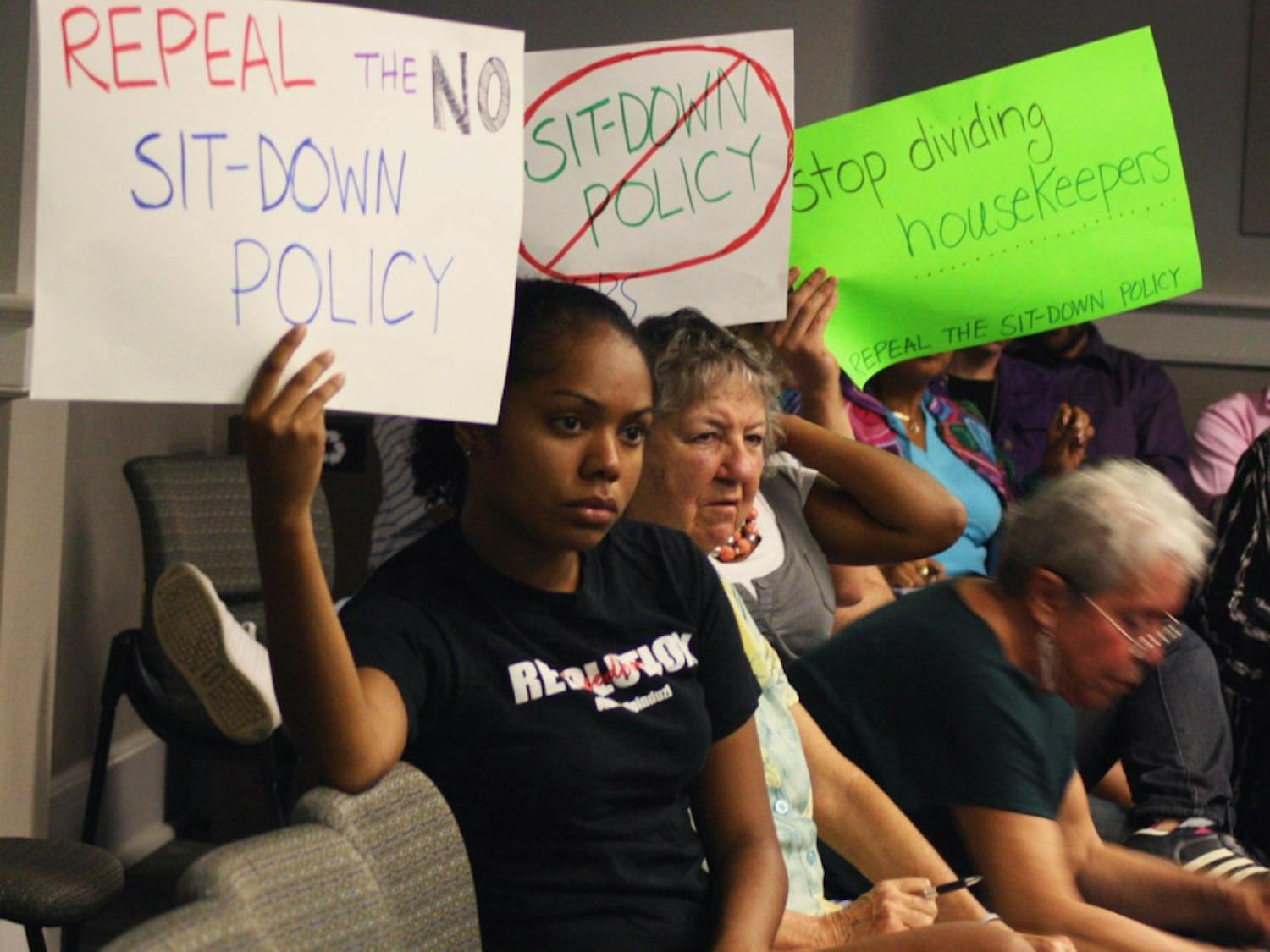 Senior Bianca Bell (left) and UNC alumna Lori Hoyt (right) hold up signs in protest of the Wage-Hour Policy at the Employee Forum in Wilson Library on Wednesday. The policy came under scrutiny after workers taking unauthorized rests were disciplined. 