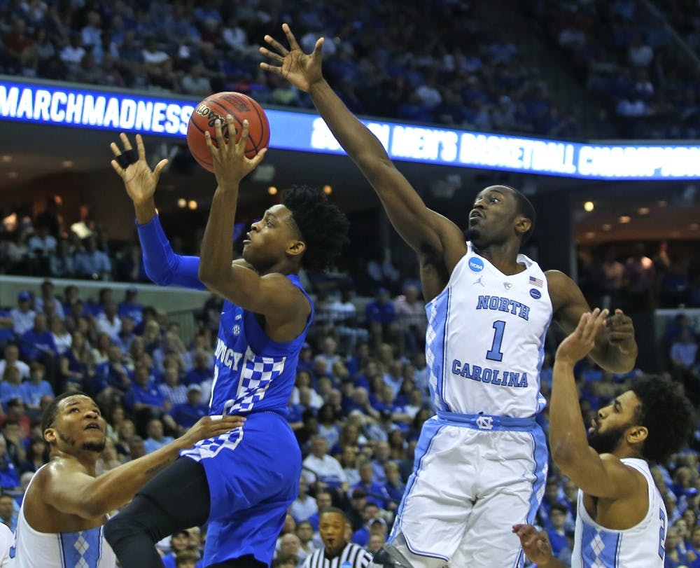 North Carolina wing Theo Pinson (1) attempts to swat the ball away from Kentucky guard D'Aaron Fox (0) in their Elite Eight matchup in Memphis on Sunday.