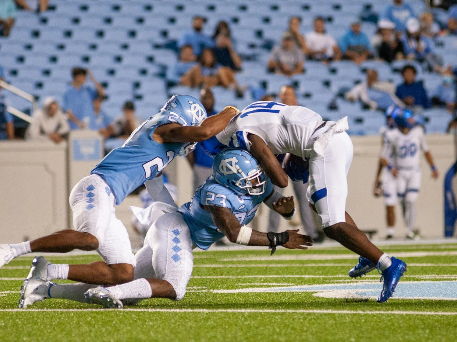 UNC junior defensive back Giovanni Biggers (27) and first year linebacker Power Echols (23) tackle a Georgia State player at the game on Sept. 11 at Kenan Stadium. UNC won 59-17.
