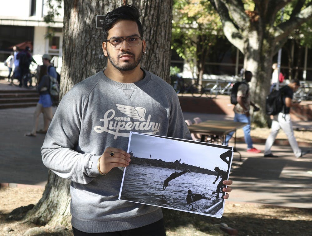 Arpan Bhandari, a religious studies and political science major,  displaying one of his photographs that are up for sale to raise money for syrian refugees. 

UN Refugee Agency 