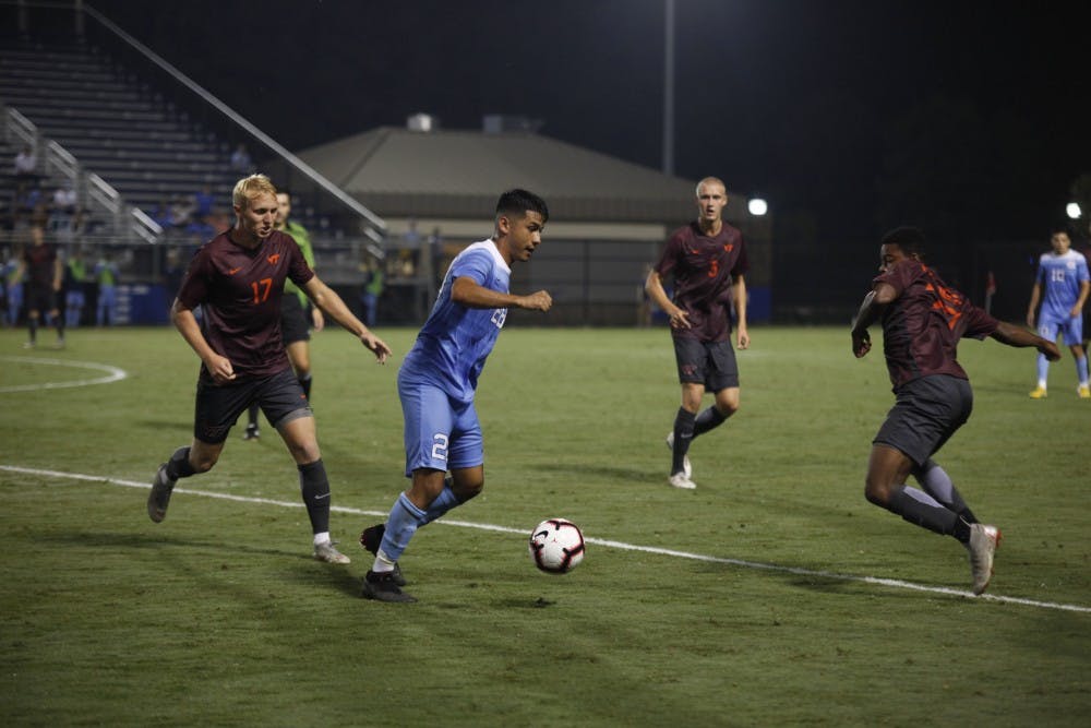 Sophomore Midfielder Raul Aguilera (28) fights to keep control of the ball against against Virginia Tech players during Saturday's game against Virginia Tech at Koskinen Stadium. UNC won 2-1.