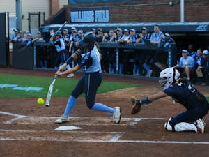 Junior Katie Perkins (11) smashes the ball at bat during the UNC women's softball game against North Carolina A&T at Anderson Softball Stadium on Wednesday, Feb. 23, 2022. The Tar Heels beat the Aggies 10-2.