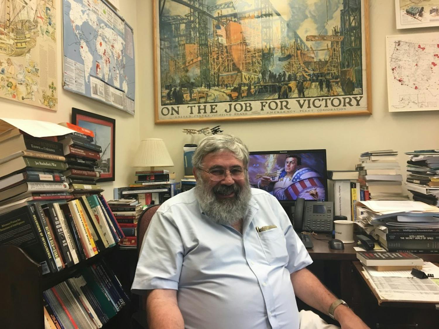 Joseph Caddell, a visiting lecturer in the History department, sits in his office — which is brimming with books and posters. 