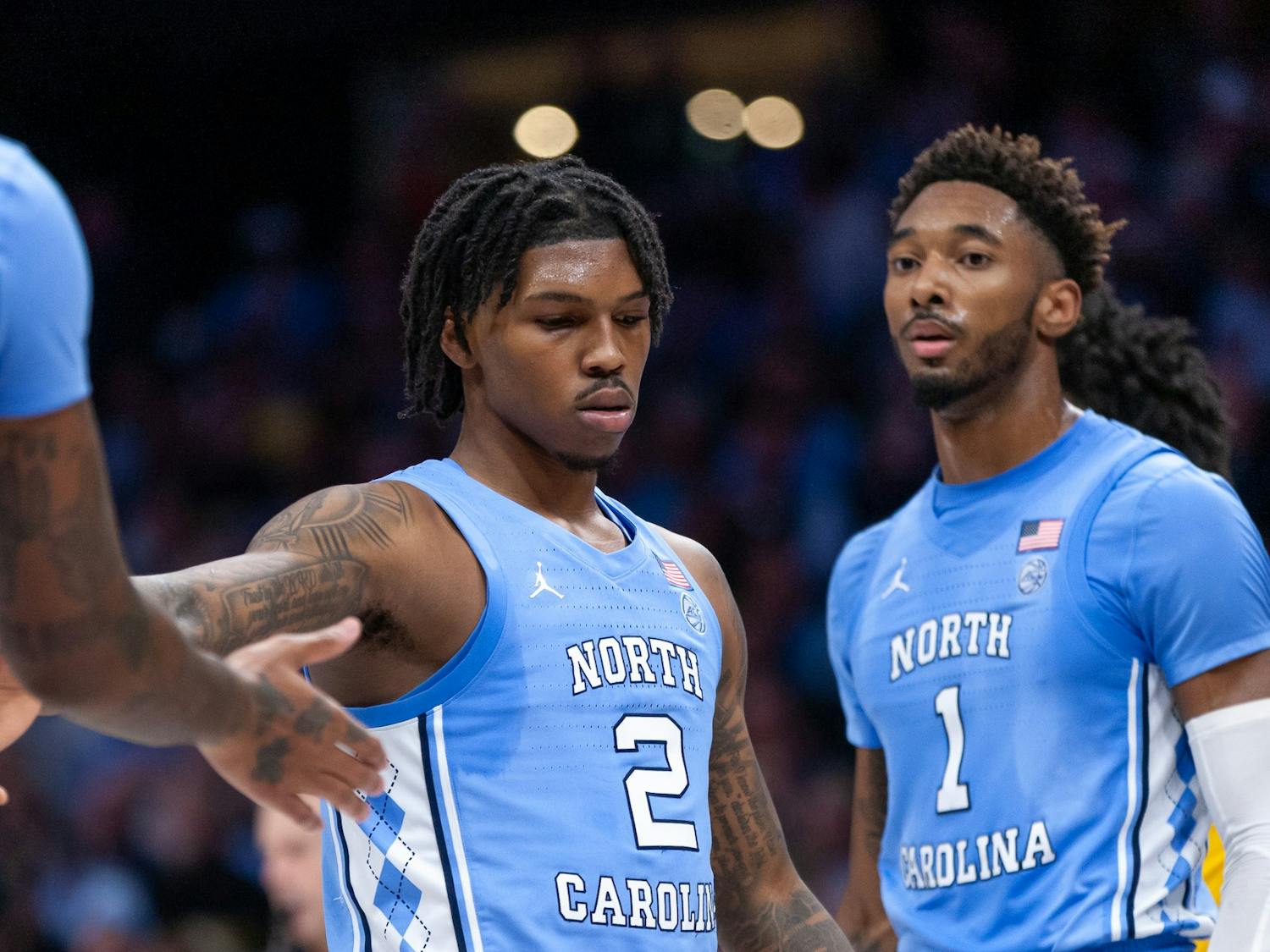 UNC junior guard Caleb Love (2) gives a high-five to senior forward/center Armando Bacot (5) during the men's basketball game against Michigan at the Jumpman Invitational in Charlotte, N.C., on Wednesday, Dec. 21, 2022. UNC beat Michigan 80-76.
