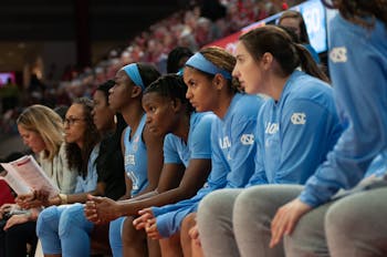 UNC players on the bench watch the game in worry at N.C. State's Reynolds Coliseum on Sunday, Jan. 26, 2020. UNC eventually lost 68-76.