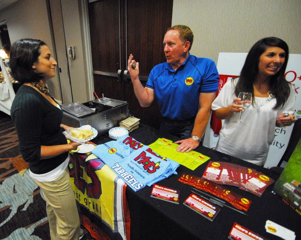 The Chapel Hill Chamber of Commerce Expo was held at the Sheraton Hotel in Chapel Hill. New Chamber members as well as returning members showcased their businesses. Kevin Rutledge and Becca Thomas of Moe's Southwest Grill in Durham share chips and queso with Samantha Handler of Aflac. Both companies were in attendance at the Chapel Hill Chamber of Commerce Expo.