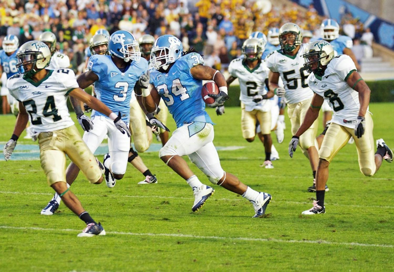 North Carolina senior tailback Johnny White zig zags his way en route to his 67-yard touchdown in the fourth quarter of Saturday’s game against William &amp; Mary. White tallied a career-high 164 yards on 29 carries. It was this go-ahead touchdown that put UNC back on top after being down by 10 points entering the final 15 minutes. 