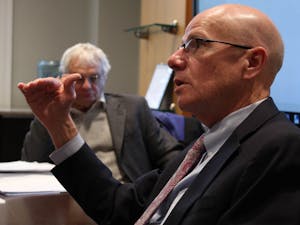 Executive Vice Chancellor and Provost Robert A. Blouin (front) and Chairperson of the Faculty Lloyd Kramer discuss lagging faculty salaries during the Faculty Executive Committee's meeting on Monday Jan. 27, 2020.