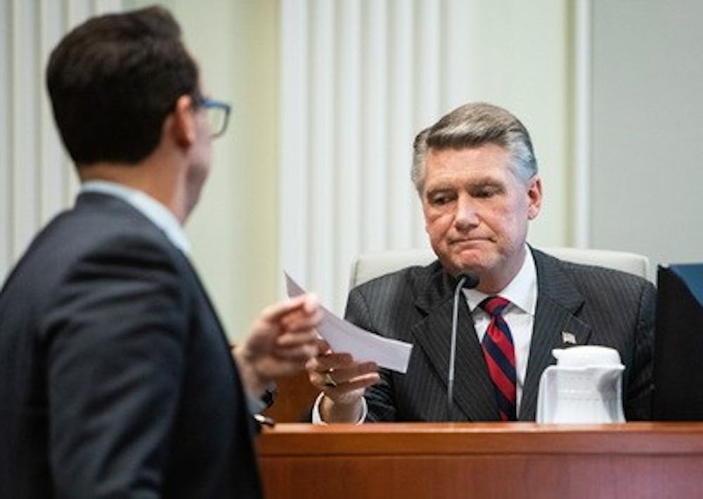 Josh Lawson, chief counsel for the state Board of Elections and Ethics Enforcement, left, hands Mark Harris, Republican candidate in North Carolina's 9th Congressional race, a document during the fourth day of a public evidentiary hearing on the 9th district's voting irregularities investigation on Thursday, Feb. 21, 2019, at the North Carolina State Bar in Raleigh, N.C. (Travis Long/Raleigh News & Observer/TNS)