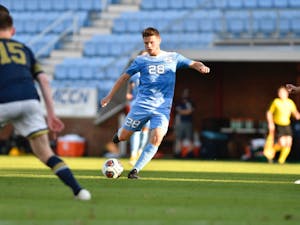 UNC's first year midfielder Tim Schels (28) kicks the ball during the first round of the ACC tournament against Notre Dame in Dorrance Field on Sunday, Nov. 15, 2020. UNC fell to Notre Dame 1-0. Photo courtesy of Dana Gentry for UNC Athletic Communications.&nbsp;