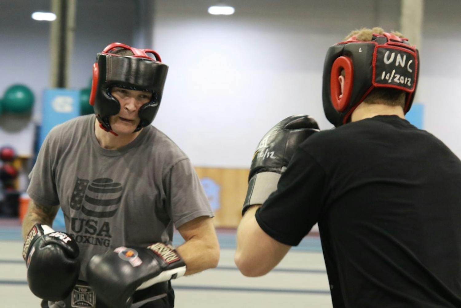 UNC club boxing coach Josh Sokal (left) practices sparring with a student in the Eddie Smith Field House on Friday evening.&nbsp;