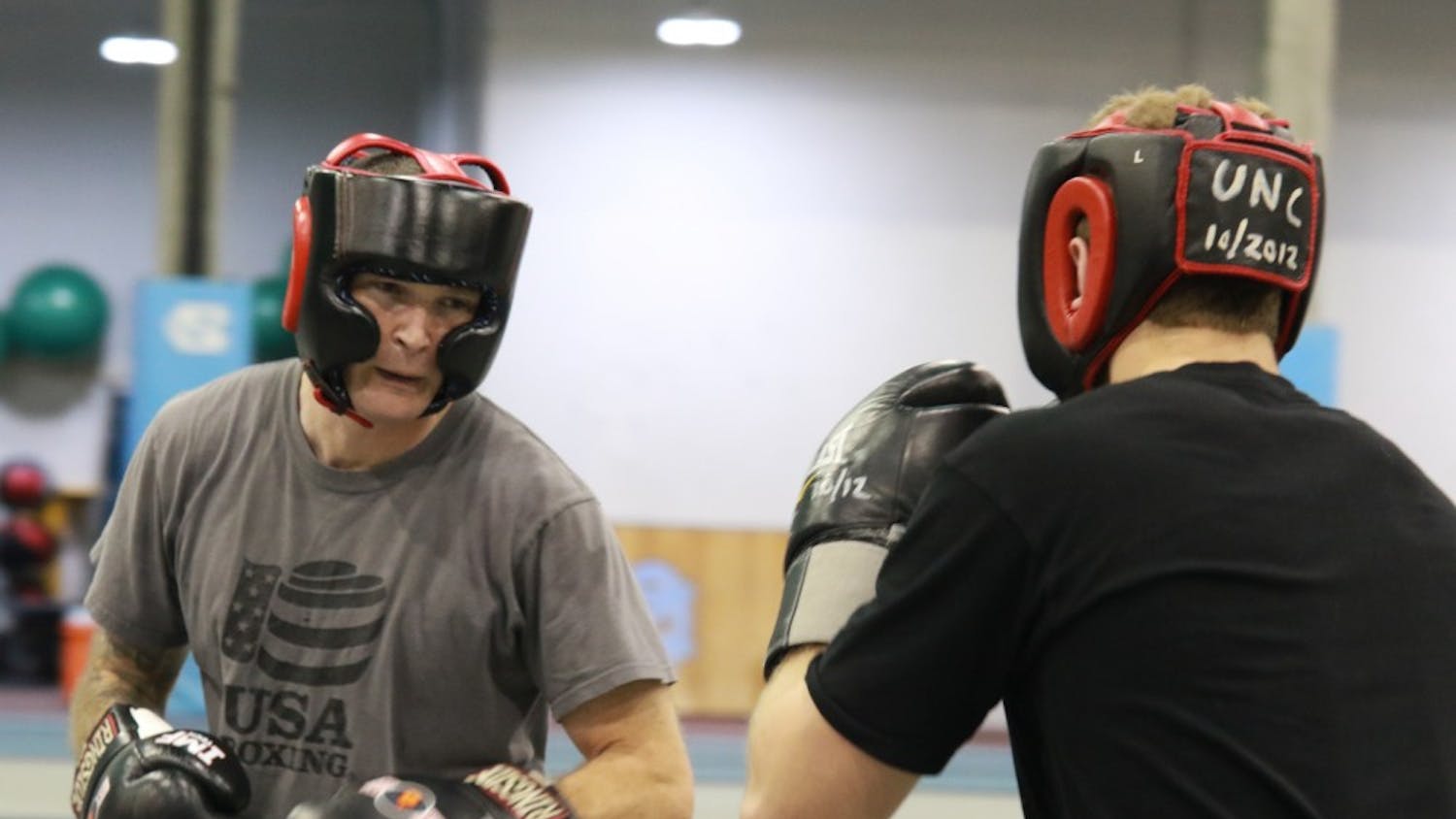 UNC club boxing coach Josh Sokal (left) practices sparring with a student in the Eddie Smith Field House on Friday evening.&nbsp;