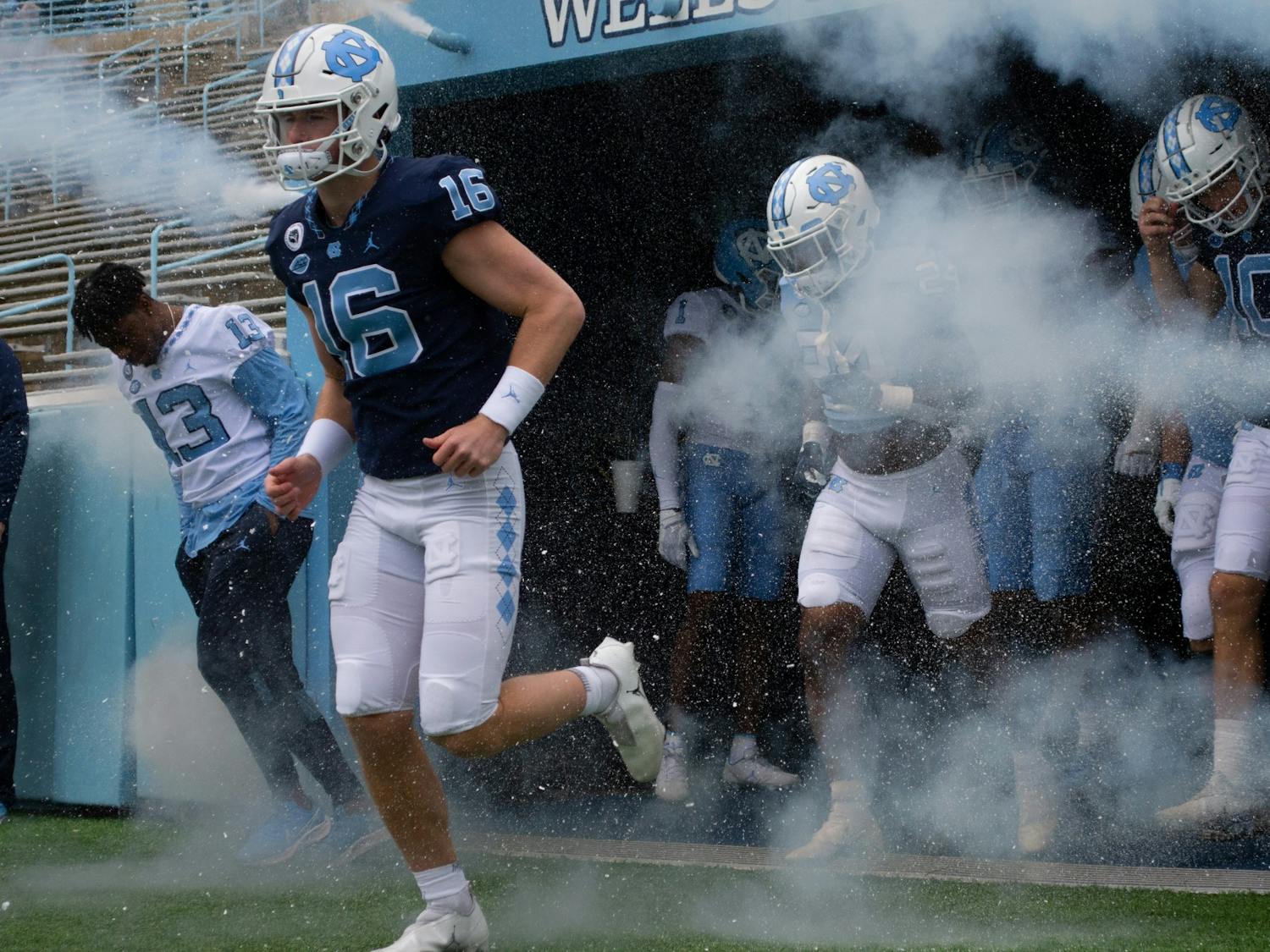 Russell Tabor (16), redshirt freshman quarterback, jogs out of the tunnel with other members of UNC's football team before their spring scrimmage in Chapel Hill, NC, on April 9, 2022.