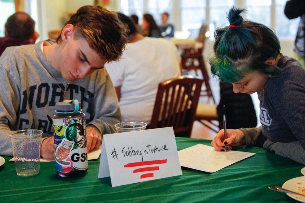 (From left to right) Sergio Jimanez, senior at Chapel Hill High School and Jasper Cobb, senior at Middle College High School at Durham Technical Community College, write letters to  Kanautica Zayre-Brown at the Queer Family Gathering dinner at a community building in Carrboro, Tuesday, March 19, 2019. Kanautica is a trans woman incarcerated at a men's prison and who has been in solitary confinement for 17 days. The letters are meant to help Kanautica maintain her mental health during her confinement until she can be moved into a women's facility.