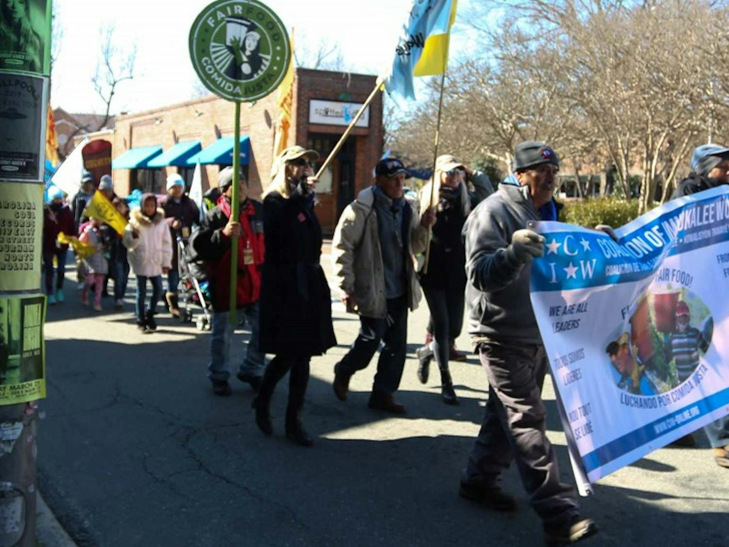 Demonstrators march on E. Main Street in Carrboro on Tuesday to protest the labor practices of Wendy’s.