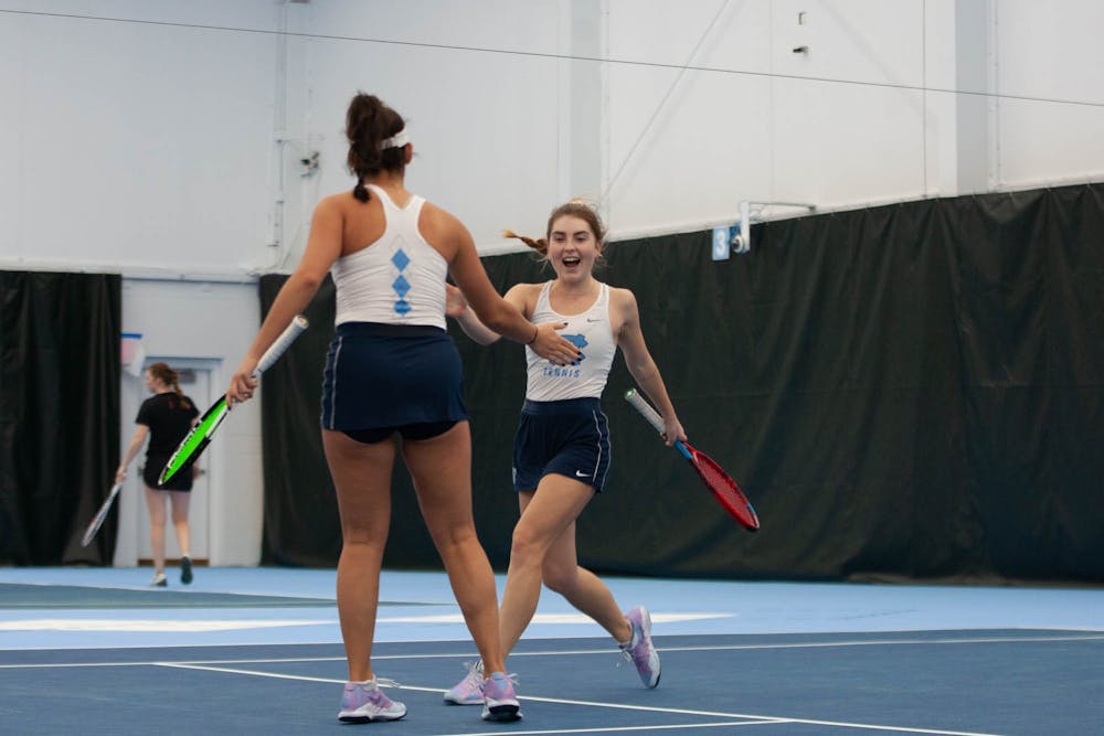 UNC Junior Fiona Crawley and Sophmore Carson Tanguilig celbrate a set win during the Tar Heel 4-0 victory over the Maryland Terrapins in the women's tennis matches on Friday, Jan 27 2023 at The Cone-Kenfield Tennis Center.
