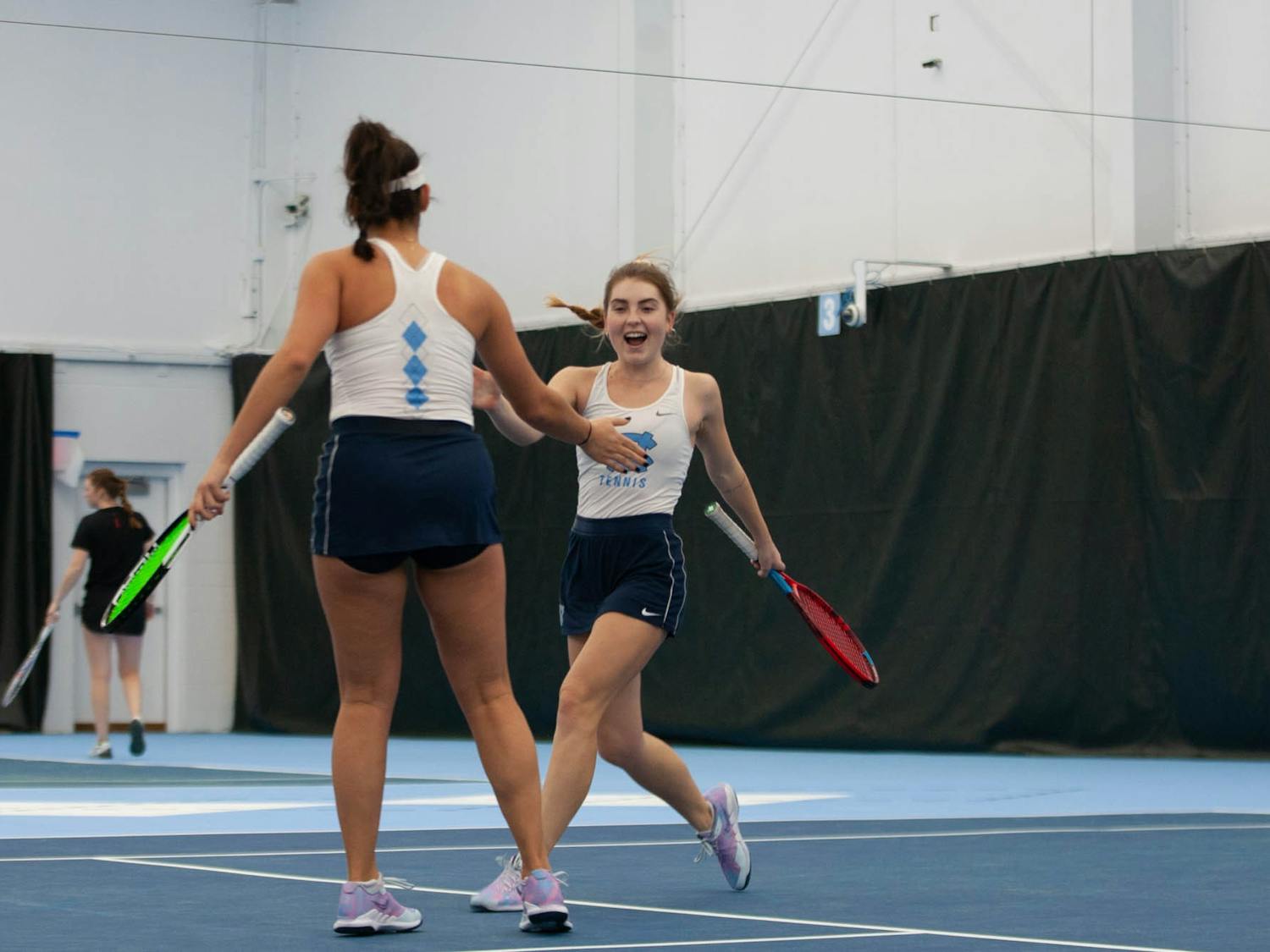 UNC Junior Fiona Crawley and Sophmore Carson Tanguilig celbrate a set win during the Tar Heel 4-0 victory over the Maryland Terrapins in the women's tennis matches on Friday, Jan 27 2023 at The Cone-Kenfield Tennis Center.