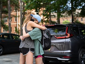 First-year roommates Jenna Barnes (left) and Ainsley Kaplan (right) hug in the Hinton James parking lot on Tuesday, Aug. 18, 2020 following UNC’s announcement that all classes will be moving to an online format.
