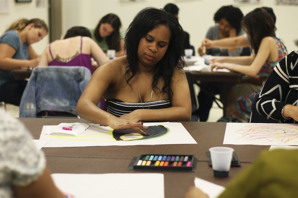 Global studies major Daleah Wilkerson paints at Healing Arts Night, hosted by Rethink: Psychiatric Illness in the Student Union on Tuesday.