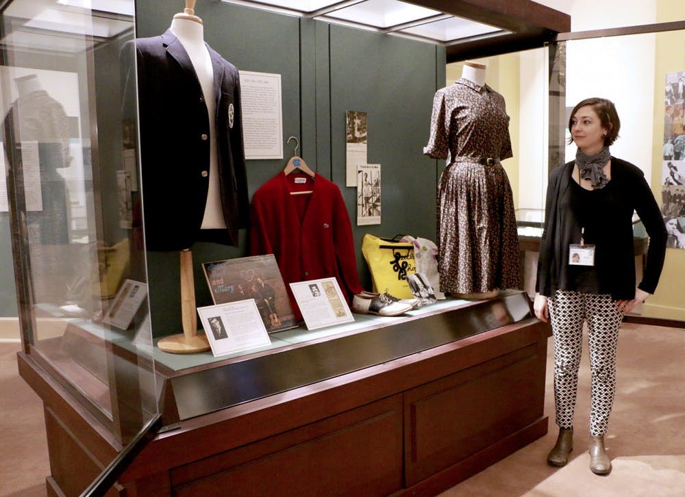 Emily Jack, the Digital Projects and Outreach Librarian for the North Carolina Collection Gallery, stands next to a display featuring clothing from the 1950s-1970s in the exhibition From Frock Coats to Flip-flops: 100 Years of Fashion at Carolina. The exhibition opened in Wilson Library this Thursday and includes nearly 60 items of clothing along with photographs, news ads, articles and excerpts from old student handbooks. 