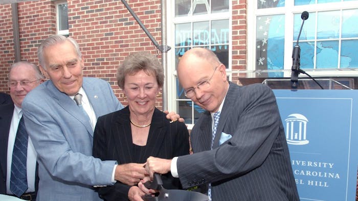 Former Chancellor Paul Hardin, left, and his wife Barbara, center, join UNC-Chapel Hill Chancellor James Moeser, right, cutting the ribbon at the dedication of Hardin Hall. Photo taken by Dan Sears and courtesy of&nbsp;UNC-Chapel Hill.