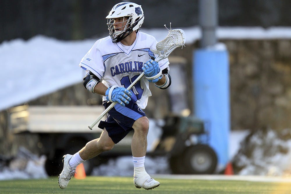 Senior attackman Joey Sankey (11) carries the ball down the field during the Feb. 27 12-10 win over the University of Denver.